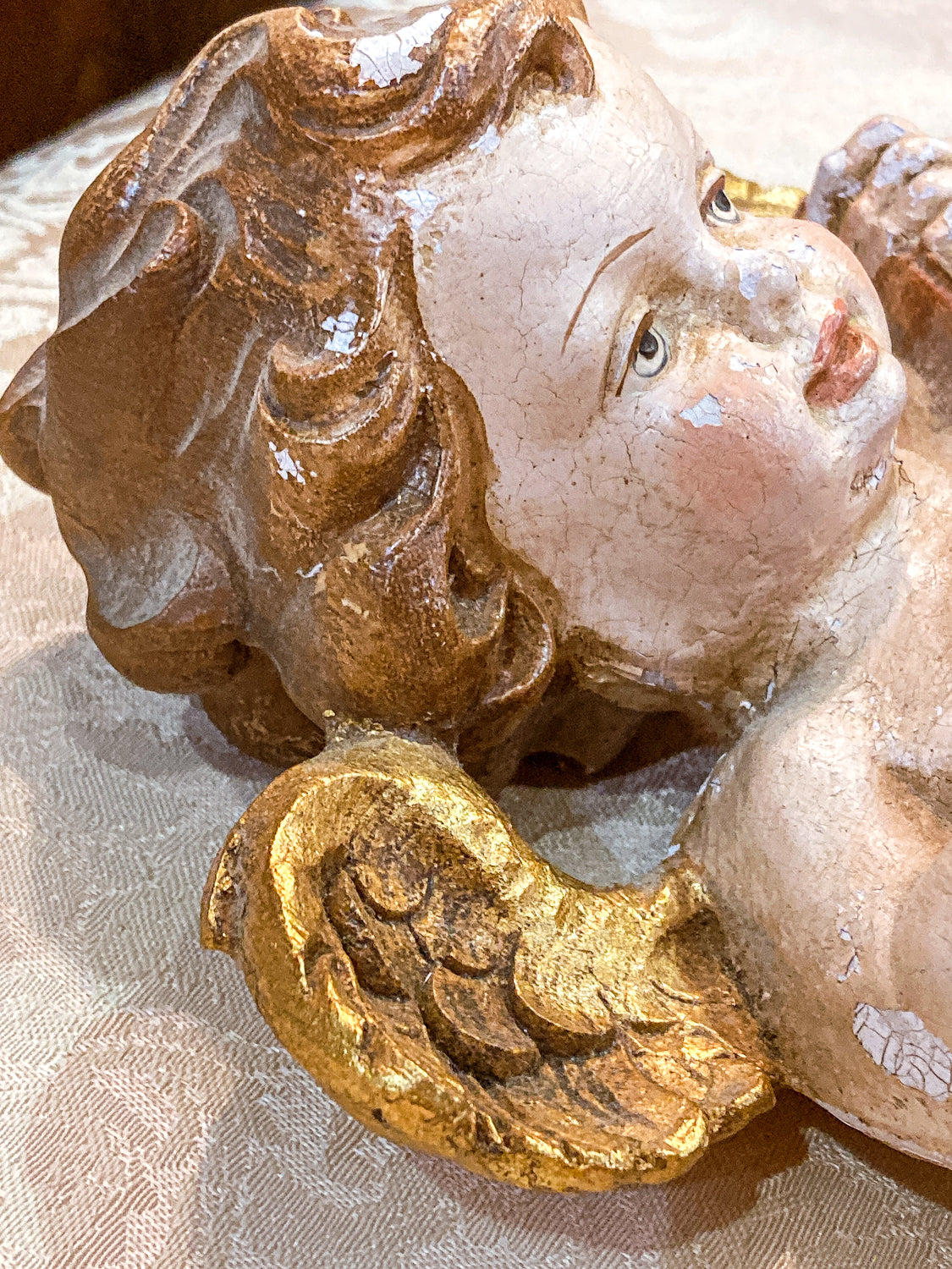Decorative angel figurine with gold accents on a textured surface 20th Century Hand Painted Gessoed Gilded Cherub Wall Hanging Sculpture
