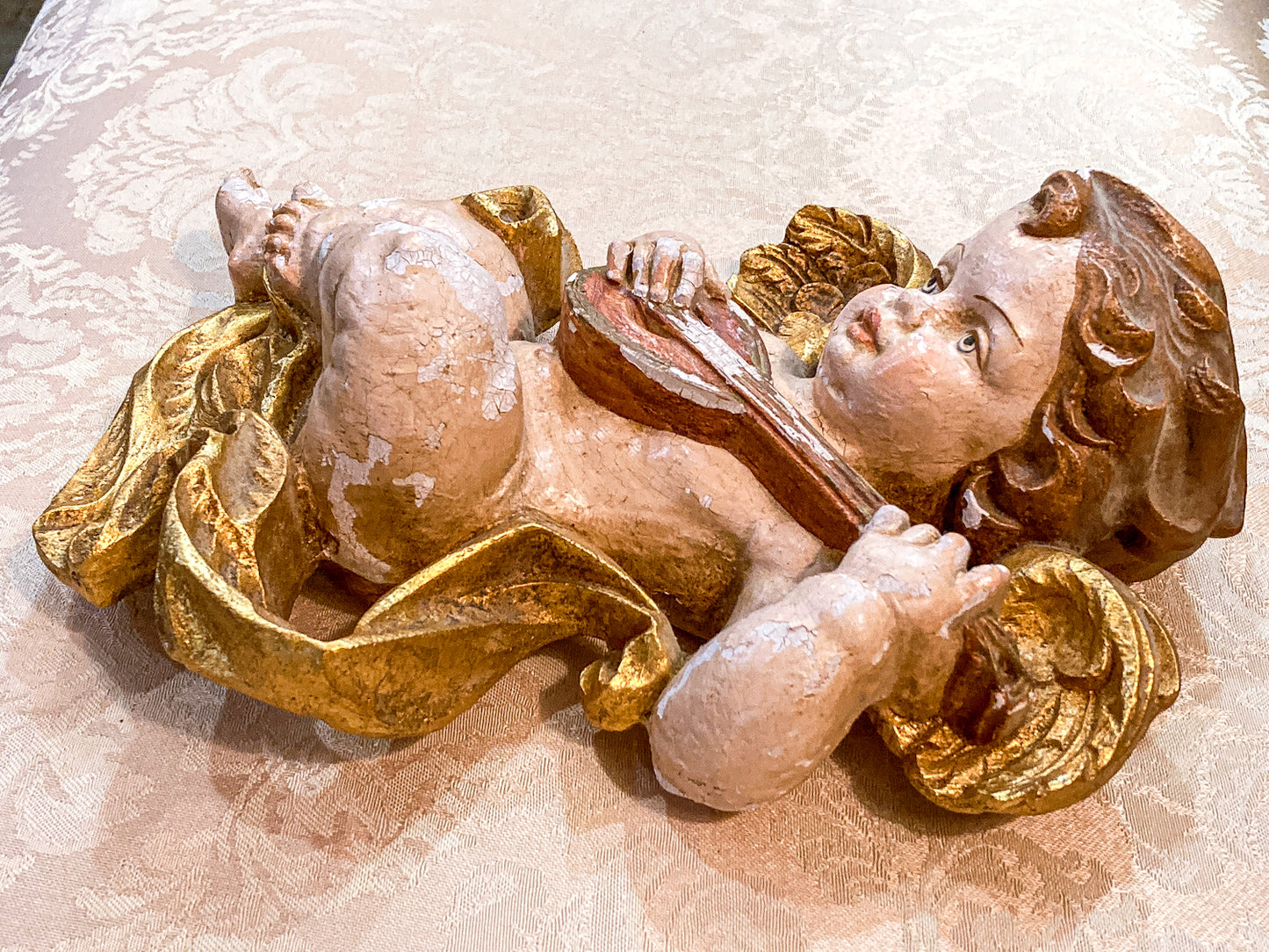Decorative angel figurine with gold accents on a textured surface
