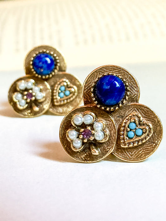 Pair of gold earrings with blue, purple, and turquoise stones on a white background Vintage Gold Tone Lucky Charm Heart Shamrock Lapis Screwback Earrings